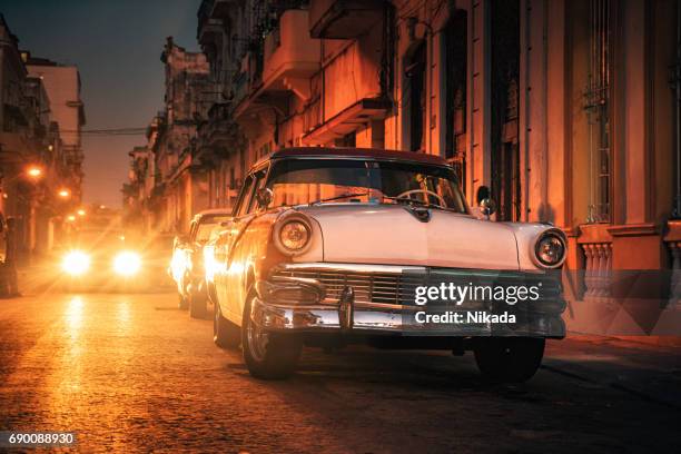 old american car on street at dusk, havana, cuba - cuba night stock pictures, royalty-free photos & images