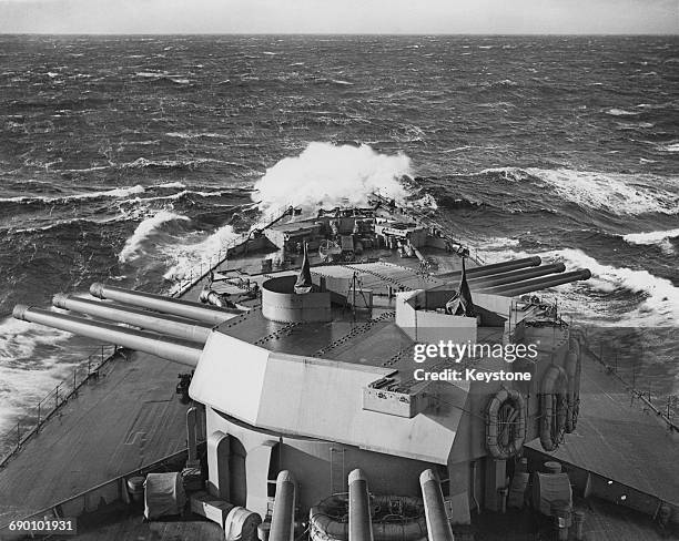 The barrells of the main armament of nine 16-inch guns mounted in triple turrets on the Royal Navy Nelson-class battleship HMS Rodney are elevated...