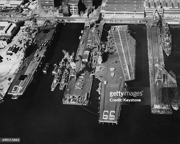 Aerial view of the Forrestal-class aircraft carrier the USS Forrestal of the United States Navy tied up alongside the smaller Midway-class aircraft...