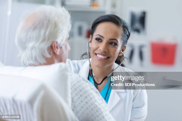 médico ausculta el corazón del paciente en el hospital - geriatría fotografías e imágenes de stock