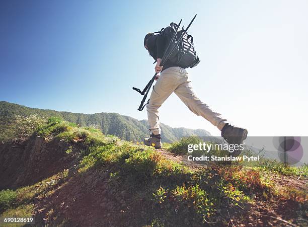 man running on grassy road in mountains - rucksack mit wanderschuhen stock-fotos und bilder