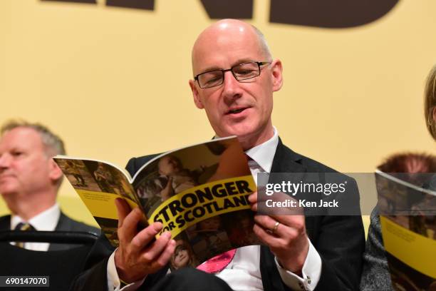 Scottish Deputy First Minister John Swinney studies a copy of the SNP general election manifesto at its launch, which was delayed for a week in the...