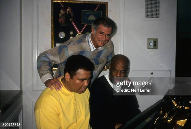 Portrait of former heavyweight champion Muhammad Ali with his friend, photographer Howard Bingham and Sports Illustrated writer Frank Deford during...