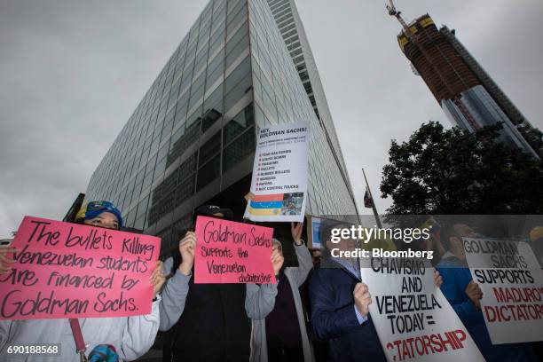 Demonstrators hold signs during a protest outside of the Goldman Sachs Group Inc. Headquarters in New York, U.S., on Tuesday, May 30, 2017. Goldman...