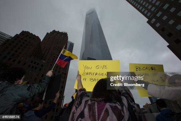 Demonstrators hold signs and wave a Venezuelan flag during a protest outside of the Goldman Sachs Group Inc. Headquarters in New York, U.S., on...