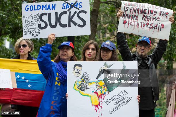 Demonstrators hold signs and a Venezuelan flag during a protest outside of the Goldman Sachs Group Inc. Headquarters in New York, U.S., on Tuesday,...
