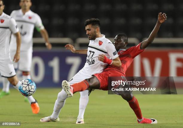 Iran's Persepolis FC midfielder Mohsen Mosalman and Qatar's Lekhwiya forward Ali Al-Moez vie for the ball during the AFC Champions League football...