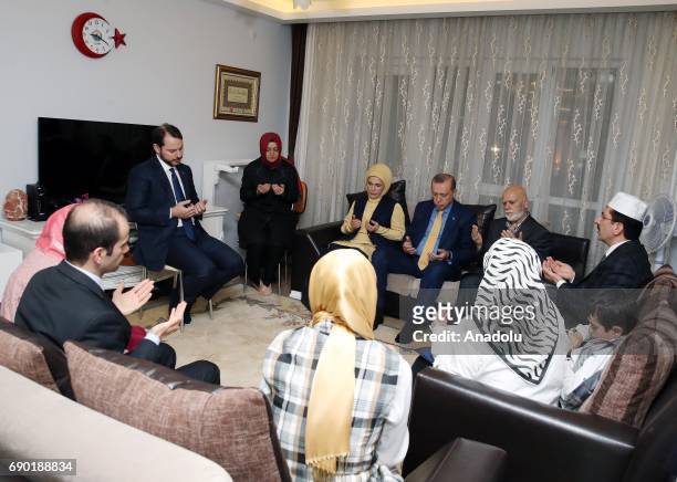 Turkish President Recep Tayyip Erdogan and his wife Emine Erdogan pray after a fast breaking meal with relatives of Cuma Dag who was martyred at...