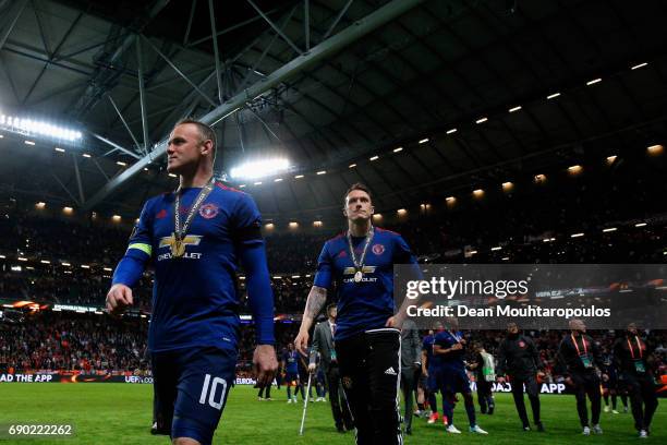 Wayne Rooney of Manchester United walks off the pitch with his winners medal after the UEFA Europa League Final between Ajax and Manchester United at...