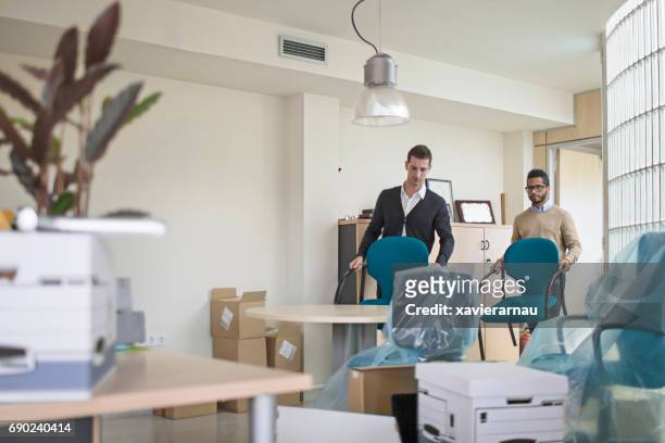 businessmen carrying chairs in new office - move to new place stock pictures, royalty-free photos & images