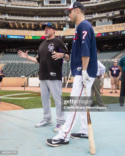 Joe Mauer of the Minnesota Twins talks with Mike Redmond of the Colorado Rockies against the Colorado Rockies on May 16, 2017 at Target Field in...
