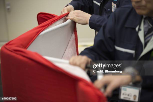 Member of a Nitori Holdings Co. Quality control team unzips a chair's cushion cover during a product test in Tokyo, Japan, on Tuesday, April 25,...