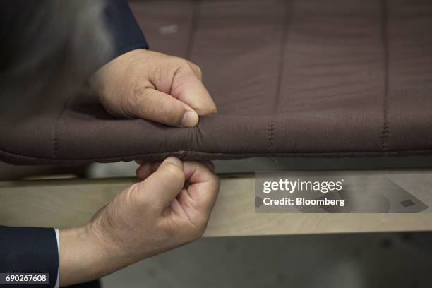 Members of a Nitori Holdings Co. Quality control team checks a seam on a chair's cushion during a product test in Tokyo, Japan, on Tuesday, April 25,...