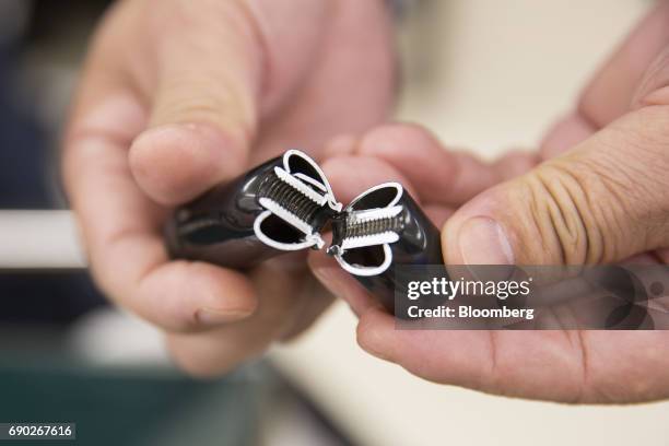 Member of a Nitori Holdings Co. Quality control displays a chair's screw for a photograph during a product test in Tokyo, Japan, on Tuesday, April...