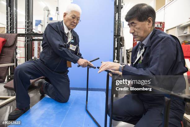Member of a Nitori Holdings Co. Quality control team cuts the metal part of a chair to check its width and the thickness of its paint coating during...