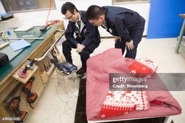 Members of a Nitori Holdings Co. Quality control team conduct heat test on a "kotatsu", a kind of Japanese table, during a product test in Tokyo,...