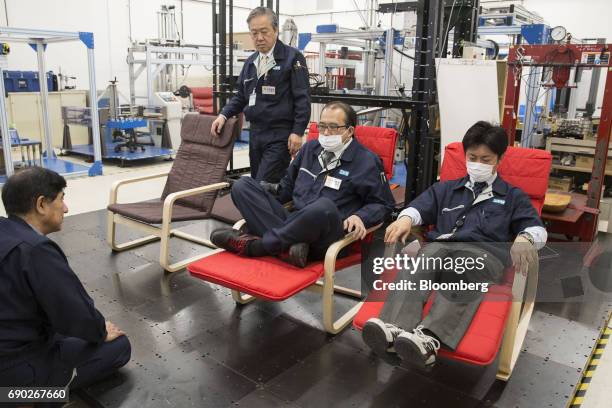 Members of a Nitori Holdings Co. Quality control team try different methods of sitting on chairs during a product test in Tokyo, Japan, on Tuesday,...