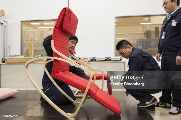Members of a Nitori Holdings Co. Quality control team rock a chair during a product test in Tokyo, Japan, on Tuesday, April 25, 2017. In the 12...