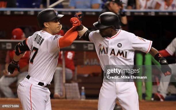 Giancarlo Stanton of the Miami Marlins celebrates a two run home run in the third inning with Dee Gordon during a game against the Philadelphia...