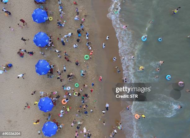 This photo taken on May 30, 2017 shows crowds on a beach in Haikou on China's southern Hainan island. Tens of thousands crowded beaches on the island...