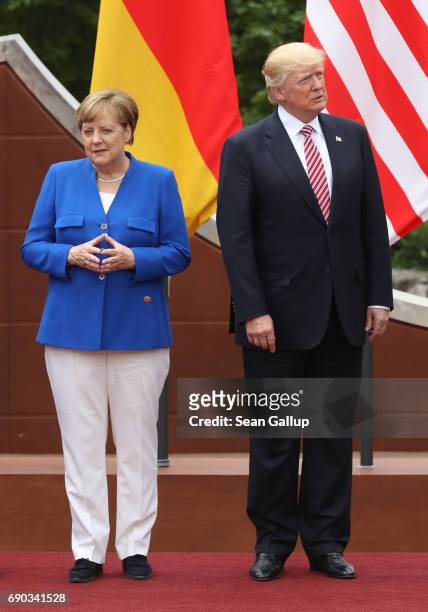 German Chancellor Angela Merkel and U.S. President Donald Trump arrive for the group photo at the G7 Taormina summit on the island of Sicily on May...