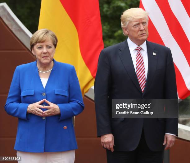 German Chancellor Angela Merkel and U.S. President Donald Trump arrive for the group photo at the G7 Taormina summit on the island of Sicily on May...