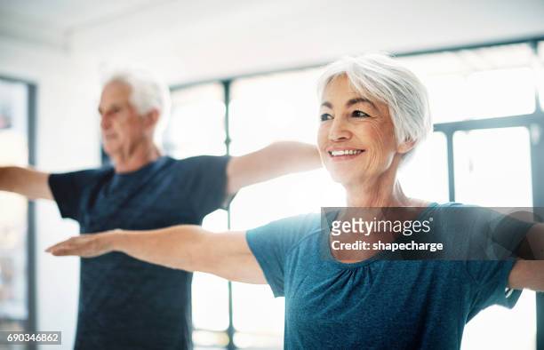 probeer te handhaven van gezonde fitness gewoonten, ongeacht uw leeftijd - woman standing exercise stockfoto's en -beelden