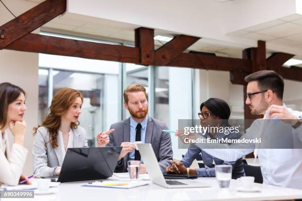 business people cooperating and exchanging ideas during formal meeting - formal office stock pictures, royalty-free photos & images