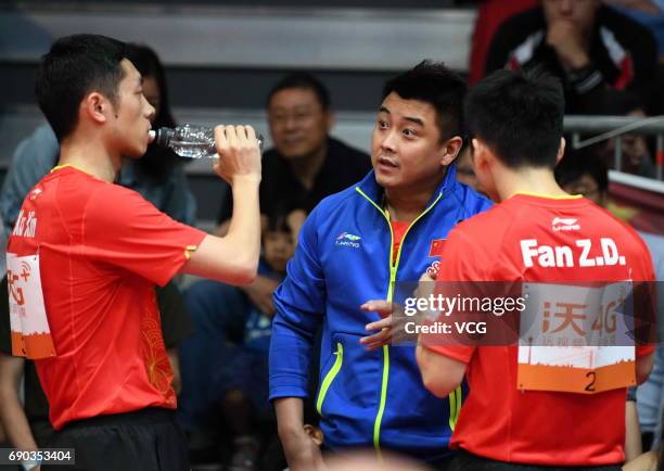 Coach Wang Hao speaks to Xu Xin of China and Fan Zhendong of China during Men's Doubles first round match on day 2 of 2017 World Table Tennis...