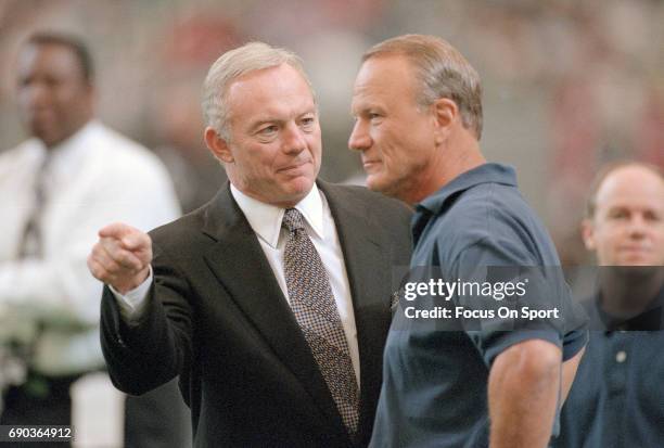 Owner Jerry Jones of the Dallas Cowboys talks with his head coach Barry Switzer while on the field prior to the start of an NFL football game circa...