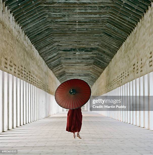 buddhist monk walking along temple corridor - angkor wat foto e immagini stock