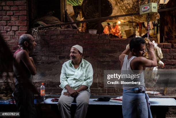 Vendor weighs live chickens at a market in Kolkata, India, on Friday, May 26, 2017. India is scheduled to release first-quarter gross domestic...