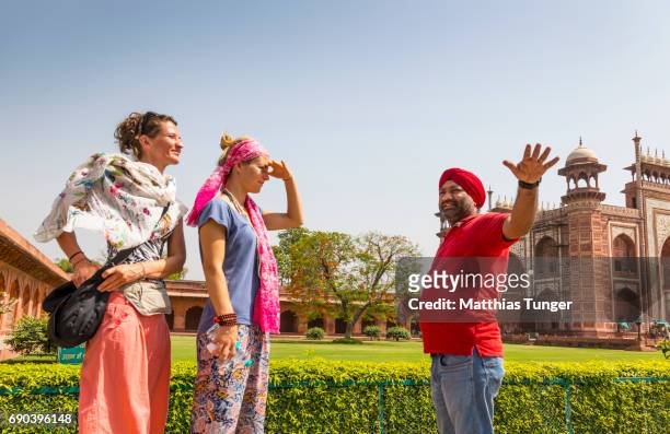 two female visitors on a tour at the taj mahal - explaining stock pictures, royalty-free photos & images