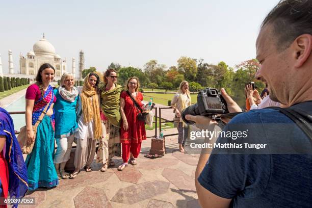 visitors on a tour at the taj mahal posing in front of the building - indian tour guide stock pictures, royalty-free photos & images