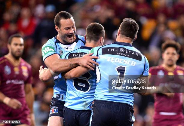 James Maloney of the Blues is congratulated by team mates after scoring a try during game one of the State Of Origin series between the Queensland...