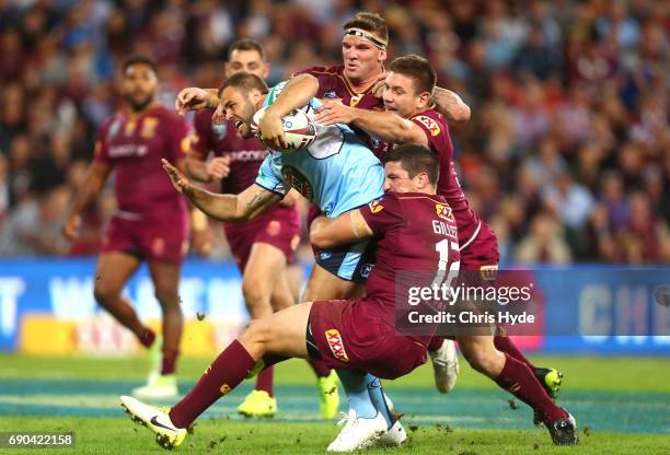 Wade Graham of the Blues is tackled by Matt Gillett and Josh McGuire of the Maroons during game one of the State Of Origin series between the...