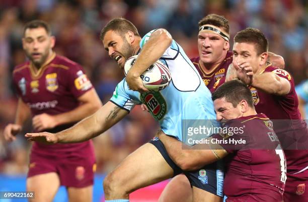 Wade Graham of the Blues is tackled by Matt Gillett and Josh McGuire of the Maroons during game one of the State Of Origin series between the...