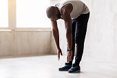 Calm african muscular guy doing warming-up exercises