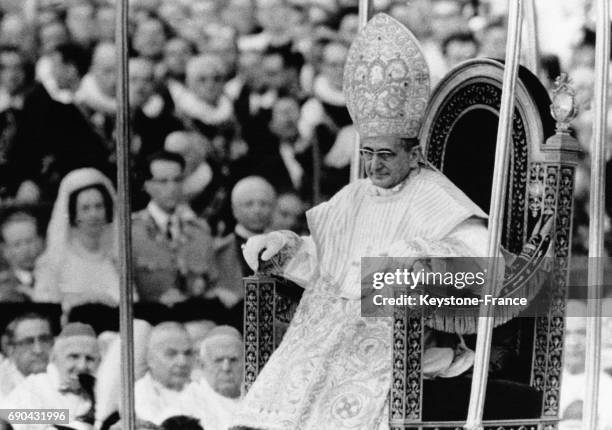 Le pape Paul VI, portant la mître et porté sur la Sedia Gestatoria, traverse la foule des fidèles après son couronnement le 1er juillet 1963 au...
