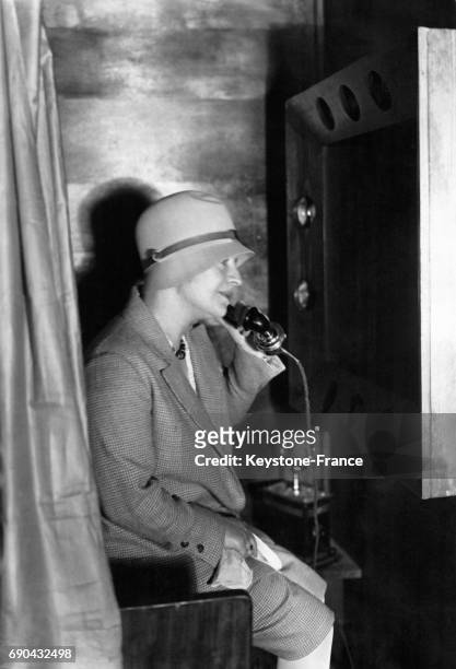 Femme testant une cabine téléphonique permettant de voir un interlocuteur, en Allemagne, le 30 août 1929.
