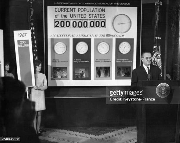 Le président américain Lyndon B Johnson devant l'appareil de recensement électronique indiquant que le 200 millionième américain est né à Washington,...