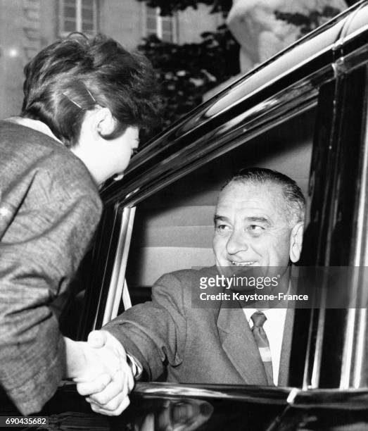 Le vice-président américain Lyndon B Johnson serrant la main à une jeune admiratrice parisienne en quittant l'ambassade des Etats-Unis à Paris,...