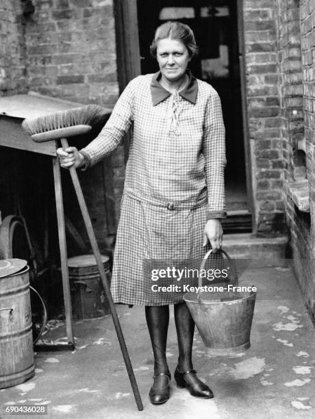 Madame AC Tabraham photographiée devant le siège du Comité de Travail où elle travaille comme femme de ménage, à Londres, Royaume-Uni le 13 mai 1929.