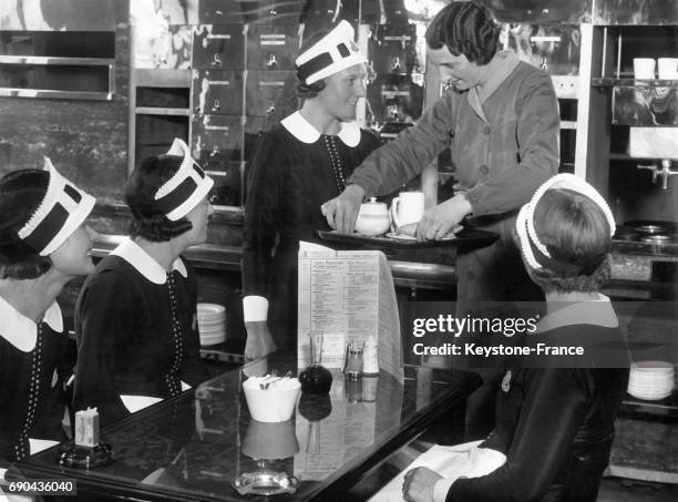 Une femme explique aux futures serveuse comment porter le plateau, à Londres, Royaume-Uni.