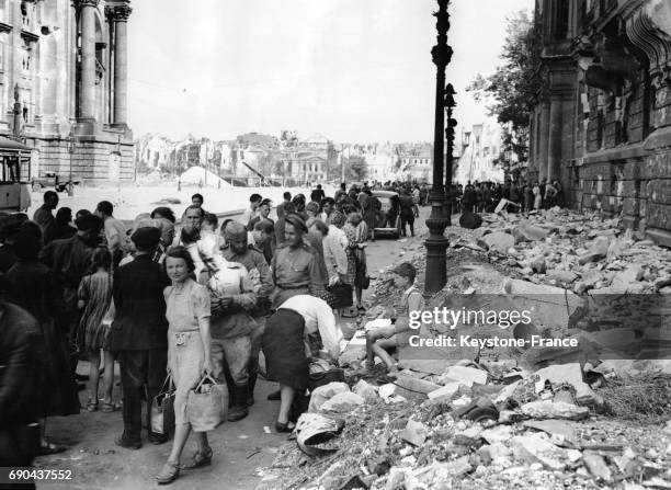 Une Allemande part faire ses courses, les sacs chargés d'argenterie à échanger contre des denrées nécessaires, à Berlin, Allemagne le 25 juillet 1945.