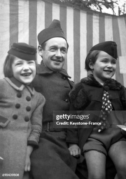 Un soldat semblant s'amuser autant que ses fillettes devant le spectacle de Guignol mobilisé, à Paris, France le 28 février 1940.