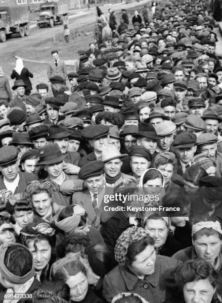 Une file d'attente sans fin de civils de toutes nationalités, mains d'oeuvres réquisitionnées par le IIIe Reich et libérés par les Forces Alliées...