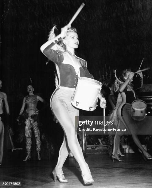 Elaine Gilda, danseuse au cabaret Latin Quarter, joue du tambour sur scène à New York City, NY.