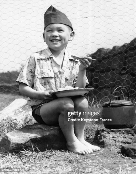 Kenny Ng Soo, 8 ans, originaire de Chine, profite d'un repas au camp d'été pour garçons des Nations Unies dans le Cheshire le 12 août 1954 au...