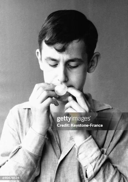 Un adolescent essaie de faire des bulles à l'aide d'un chewing-gum.